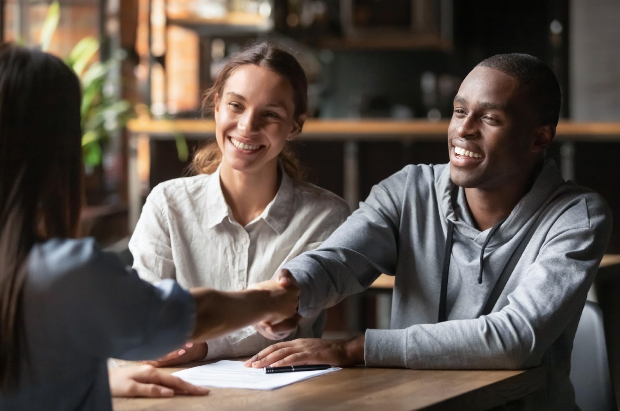 A_couple_shaking_hands_on_successful_approval_of_their_business_loan.jpg